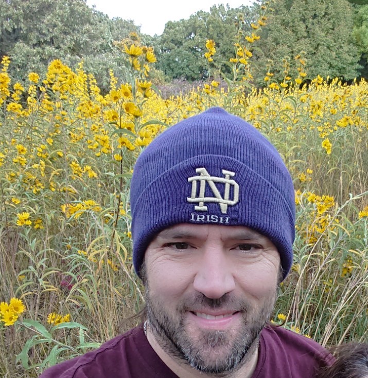 Picture of Jon in a field of yellow flowers.
