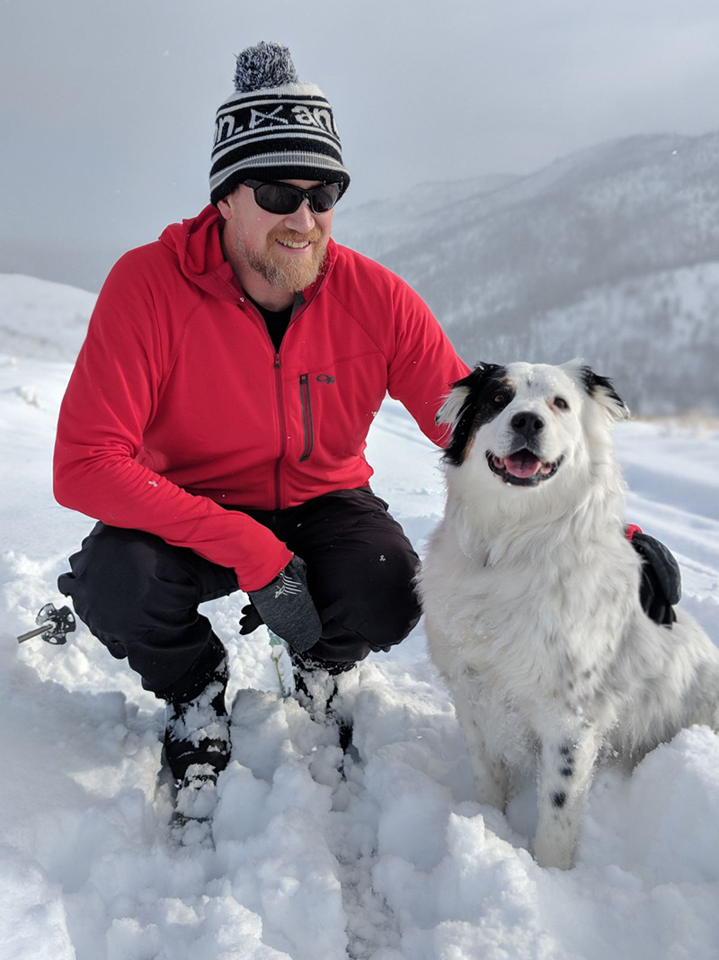 Picture of Ryan with his dog in the snow.
