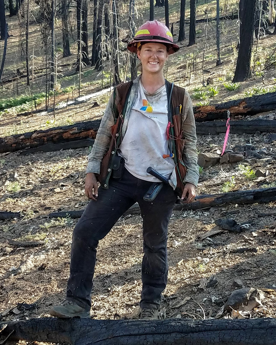 Picture of Sarah in fire gear in a forest.